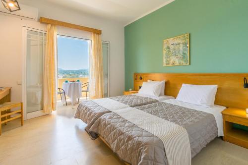 um quarto com uma cama e uma grande janela em Elite Corfu - Adults Friendly em Kommeno