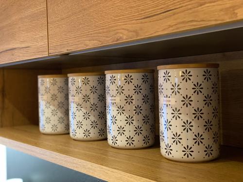 four white cups are sitting on a shelf at Chalet Tuxer in Achenkirch