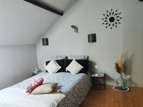 um quarto com uma cama com almofadas em Gite de la tannerie 3 em Dinan