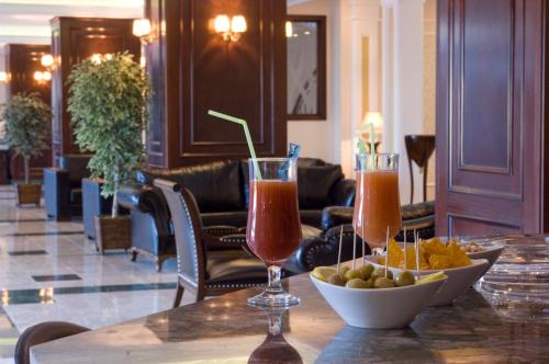 a table with two drinks and a bowl of food at Hotel Monec in Ankara