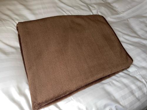 a brown book sitting on top of a bed at Oita Regal Hotel in Oita