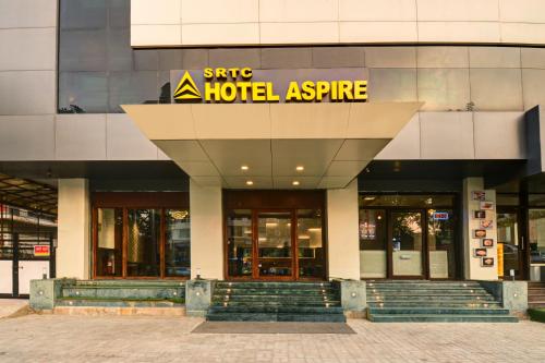 une entrée d'hôtel avec un panneau sur un bâtiment dans l'établissement SRTC Hotel Aspire, à Ahmedabad