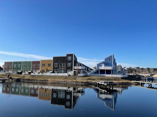 a group of buildings sitting next to a body of water at Perle Øer Maritime ferieby Ebeltoft in Ebeltoft
