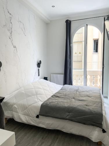 a bedroom with a large bed and a window at Villa Berlioz in Nice