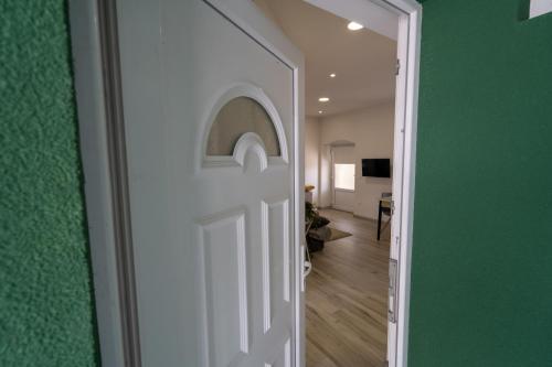 a door leading into a room with a green wall at Apartman TONKOVIĆ in Imotski