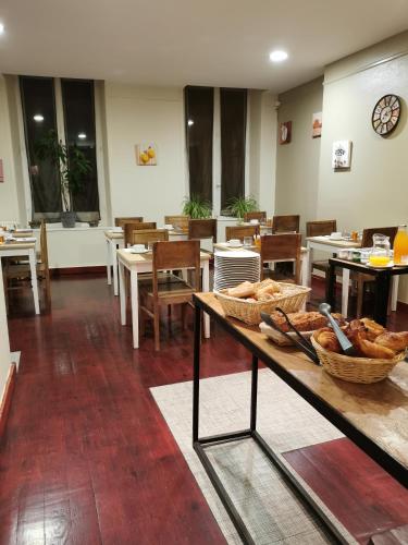 a restaurant with a table with baskets of bread on it at Hôtel François d'O in Caen