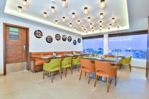 a restaurant with tables and chairs and a large window at SureStay by Best Western Heritage Walk in Amritsar