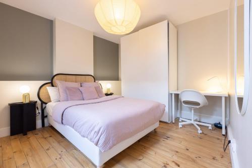 une chambre avec un grand lit blanc avec des oreillers roses dans l'établissement HIMA, Beau T2 rénové à neuf Châteaucreux Gare, à Saint-Étienne