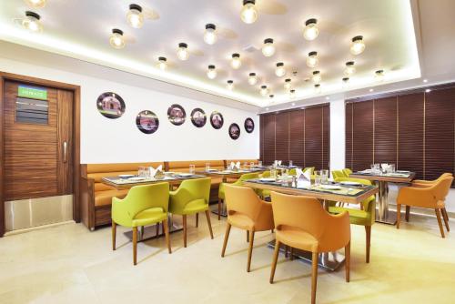 a dining room with tables and yellow chairs at SureStay by Best Western Heritage Walk in Amritsar