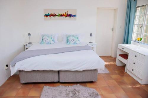 una camera da letto con un letto grande e un bagno di Oakdene Cottage a Roodepoort