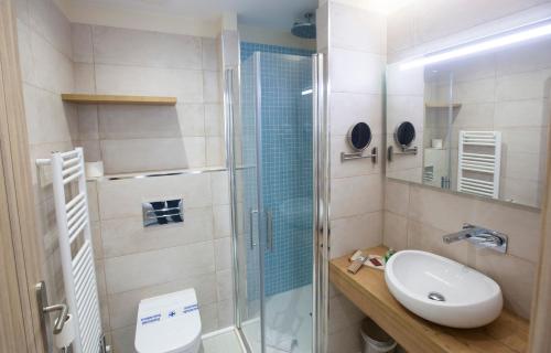 a bathroom with a toilet and a sink and a shower at Hotel Boutique O Náutico Laxe in Laxe