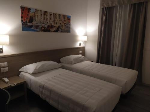 2 letti in una camera d'albergo l'una accanto all'altra di Hotel Nova Domus Aurelia a Roma