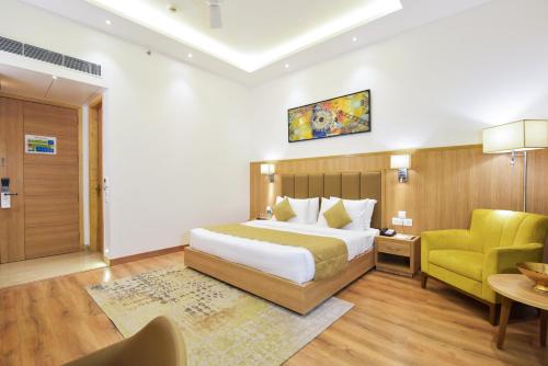 a hotel room with a bed and a yellow chair at SureStay by Best Western Heritage Walk in Amritsar