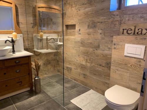 a bathroom with a toilet and a glass shower at Büehl Lenk in Lenk
