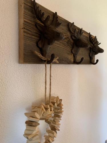 a wooden sign with a moose head on a wall at Büehl Lenk in Lenk