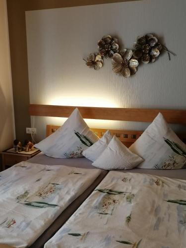 two beds in a bedroom with flowers on the wall at Eifelferienwohnungen "Familie Saxler" in Bereborn