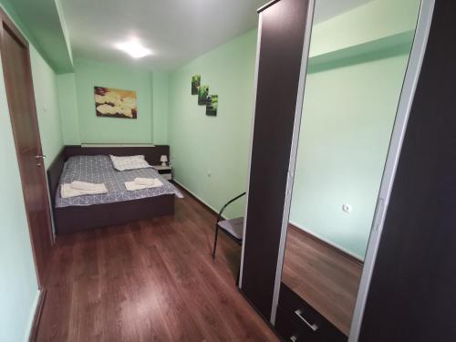 um pequeno quarto com uma cama e um espelho em Двустаен апартамент в центъра на гр. Бургас em Burgas