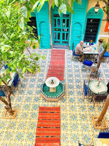 a man sitting at a table in front of a house at Riad Al Nour in Marrakech