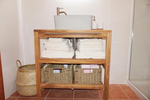a shelf with towels and a sink in a bathroom at Evasion Corse Direct mer Piscine Terrasse in Moriani Plage