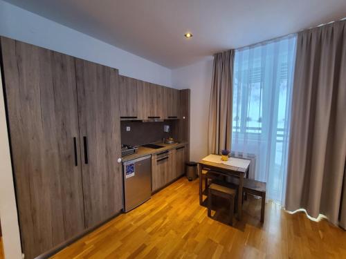 une cuisine avec des placards en bois, une table et un bureau dans l'établissement Bela Brada - Brzeće, Kopaonik, à Brzeće