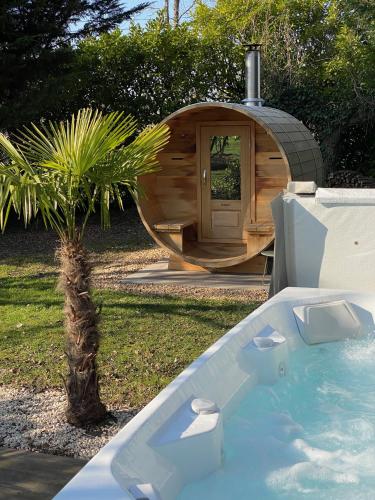 a small palm tree in front of a wooden sauna at LA DEMALERIE in Cheverny