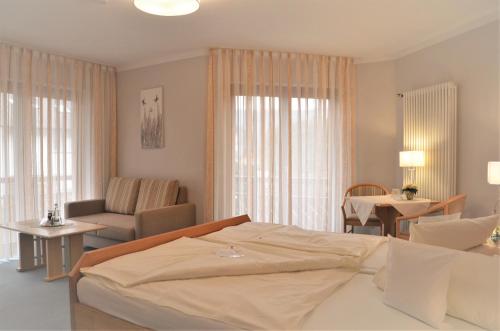 a bedroom with a bed and a table and chairs at Hotel-Pension Breig Garni in Ottenhöfen