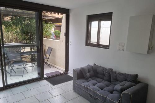 un salon avec un canapé et une terrasse dans l'établissement Naturiste Cap d'Agde Port Vénus 1, au Cap d'Agde