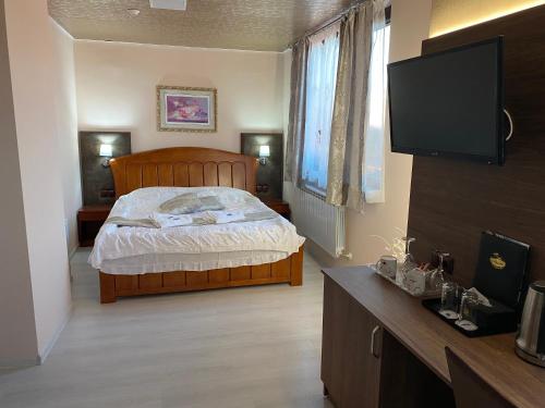 a bedroom with a bed and a flat screen tv at Complex Koko Hills in Sapareva Banya