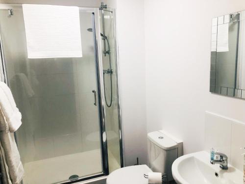 a bathroom with a shower and a toilet and a sink at Friars House, Stafford by BELL Apartments in Stafford