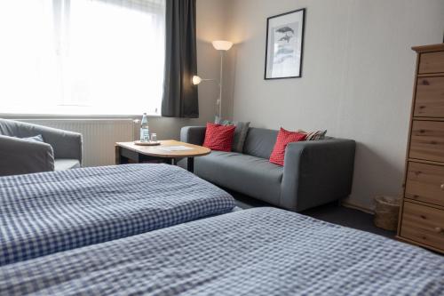 a hotel room with two beds and a couch at Heimathafen in Büsum