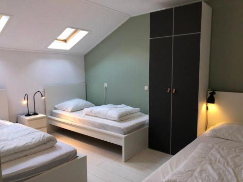 a bedroom with two beds and a skylight at Naar Zee op Ameland in Buren