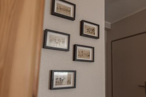 a row of framed pictures on a wall at Heimathafen in Büsum