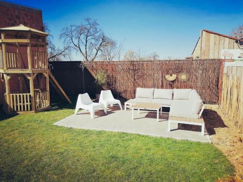 a patio with a couch and two chairs and a table at Vakantiewoning Spoor 23 in Borgloon