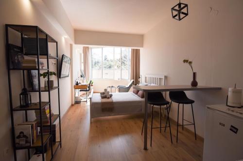 a living room with a table and chairs and a bed at Gravity Downtown Scandi Studio in Rhodes Town