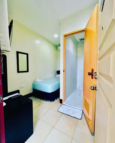 a small room with a bed and a door at Park Avenue Residence Inn and Suites in Davao City