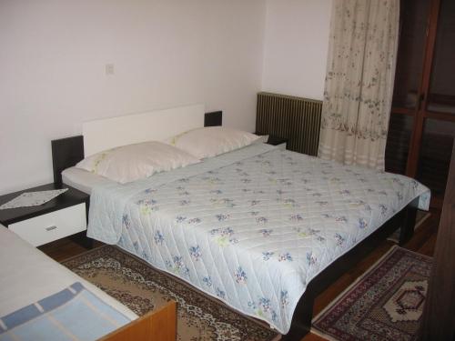 a bedroom with a bed with a white comforter at Apartment Kalvarija in Novi Vinodolski