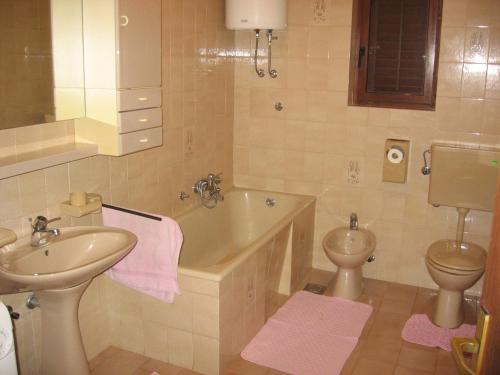 a bathroom with a sink and a tub and a toilet at Apartment Kalvarija in Novi Vinodolski