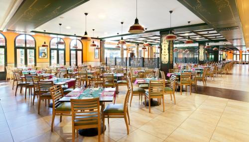 a dining room with tables and chairs in a building at Barceló Punta Umbría Beach Resort in Punta Umbría