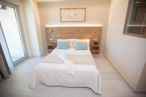 a bedroom with two beds and a large window at Hotel Boutique O Náutico Laxe in Laxe