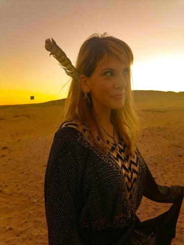 a woman standing on the beach at sunset at Safari Abu Simbel in Abu Simbel