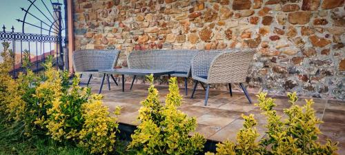 2 rieten stoelen en een tafel op een patio bij Casa Rural Asitxo in Bermeo