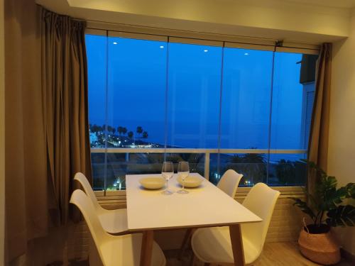 una mesa con dos copas de vino delante de una ventana en Apartamento Ohana, Costa del Sol, en Algarrobo Costa
