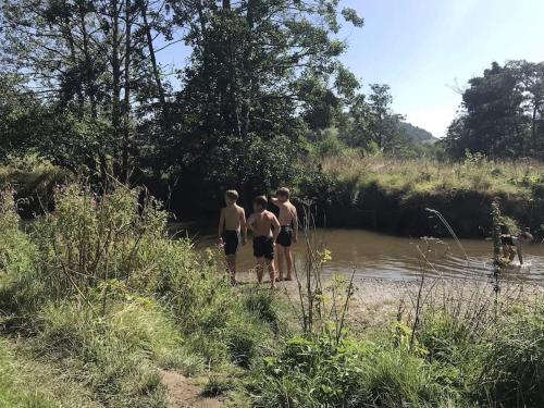 three boys are walking in the water near a river at Spacious ground floor apartment. No 1A The Stables in Llanfyllin