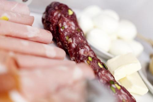 a close up of two sausages on a plate with cheese at Iblaresort Boutique Hotel in Ragusa