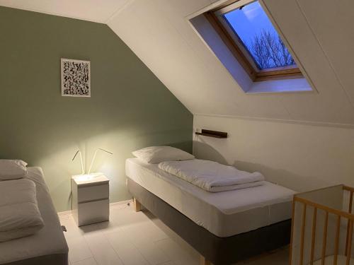 a attic bedroom with two beds and a window at Noorderzon in Buren