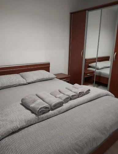 a bedroom with a bed with towels on it at TALINA Apartament in Oradea