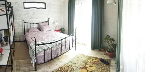 um quarto com uma cama com almofadas cor-de-rosa em Солнечный дом у друзей em Tbilisi