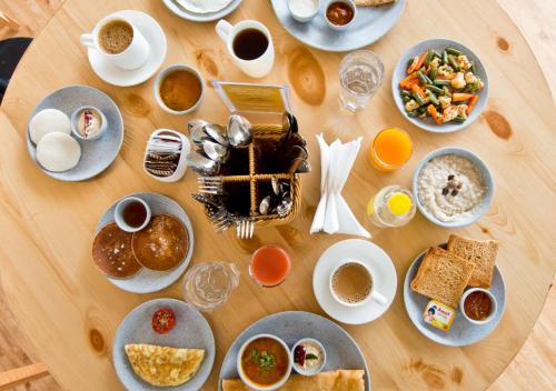 een tafel met borden eten en kopjes koffie bij Bloomrooms Calangute in Calangute