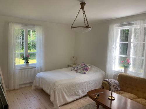 a bedroom with a bed and a couch and windows at Linsell nyrenoverad lägenhet in Linsell