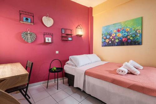 a room with two beds and a table and a painting at Blossom in Ierapetra